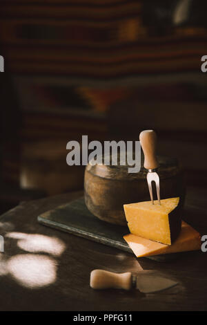 Deux sortes de tranches de fromage avec une fourchette sur une table en bois rustique Banque D'Images
