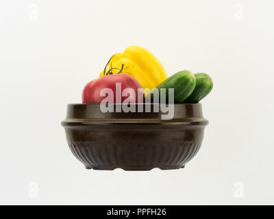 Différents légumes frais dans un bol en céramique sur fond blanc en perspective horizontale, et découper l'espace de copie Banque D'Images