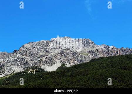 Montagne sans neige partiellement couvert par une forêt contre le ciel bleu clair en été Banque D'Images