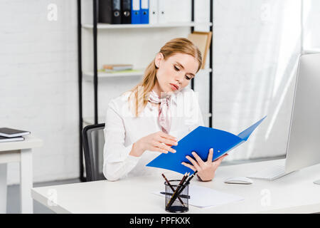 L'accent young businesswoman reading documents au bureau moderne Banque D'Images