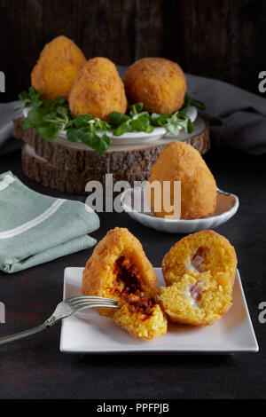 Arancini, cuisine italienne traditionnelle, principalement sicilien, farcies de viande et de pois ou de ragoût, soi-disant beurre, farcies au jambon et fromage mozzarella. Banque D'Images