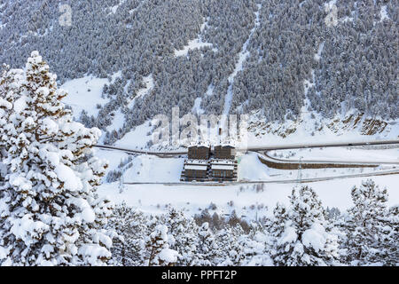 La vue de dessus sur l'hôtel en station de ski en Andorre. Le bâtiment et la route dans les montagnes entre les pentes de sapins dans la neige Banque D'Images