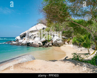 Belle plage des Caraïbes solitaire avec palmiers et grand rond de pierre dans le Parc National Tayrona près de Santa Marta, dans le Nord de la Colombie Banque D'Images