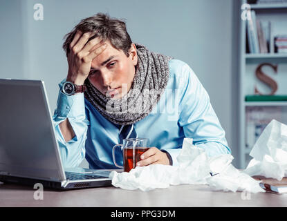 Mauvaise sensation. Travailleur malade a haute température. Photo de jeune homme dans la souffrance du bureau de virus de la grippe. Concept médical. Banque D'Images