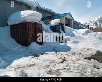 Installations de production de neige-couvertes dans le contexte d'une colline couverte de neige avec les glaçons sur le toit en hiver sur une journée ensoleillée Banque D'Images