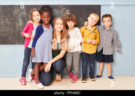 Groupe d'enfants et l'enseignant comme amis ensemble en maternelle ou au jardin d'enfants Banque D'Images