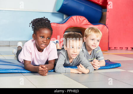 Les enfants multiculturels en amis dans la salle de sport à la maternelle ou à la garderie Banque D'Images