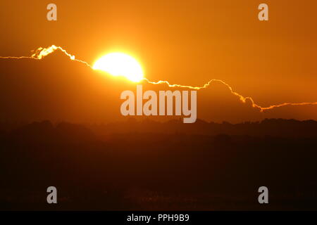 Le soleil derrière les nuages, vu de la RSPB St Aidan's Nature Park à Leeds Banque D'Images