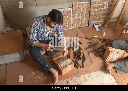 Carpenter à l'aide d'un ciseau pour faire des dessins et sculptures sur bois dans son atelier. Banque D'Images