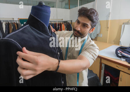 Adapter mettre une couche semi-cousues sur un mannequin dans son atelier pour vérifier le montage. Banque D'Images