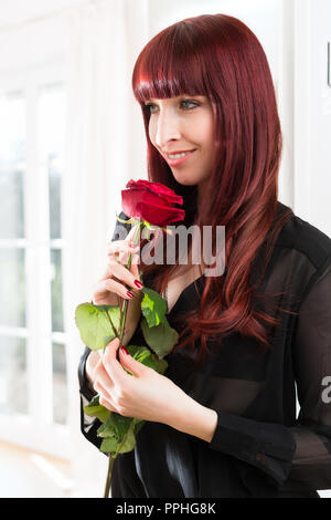 Smiling woman holding rose Banque D'Images