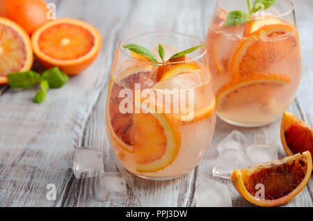 Sang Froid boisson rafraîchissante avec des tranches d'orange dans un verre sur un fond de bois. Banque D'Images