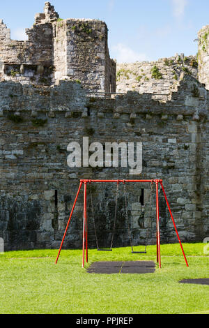 Château de Beaumaris à Beaumaris avec swing pour enfants parc en face. Anglesey, au nord du Pays de Galles Banque D'Images