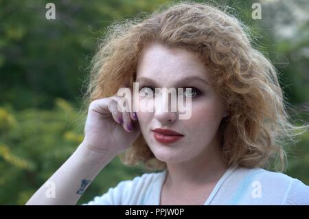 Portrait de jeune femme blonde, fond vert Banque D'Images