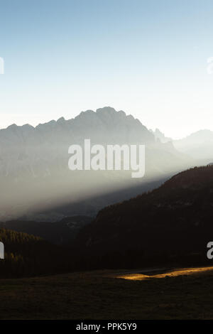 Premier rayon de lumière sur un matin brumeux dans les Dolomites, Italie Banque D'Images