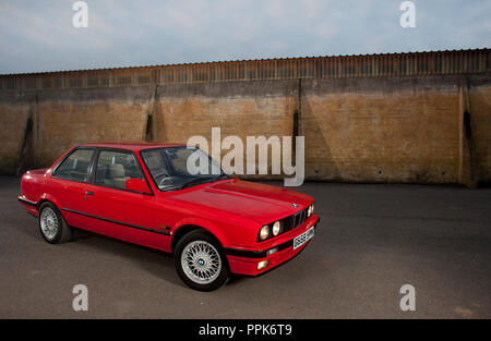 Une droite UK spec 1990 rouge porte 3 BMW E30 série 3 sur une zone industrielle en Angleterre, Royaume-Uni Banque D'Images