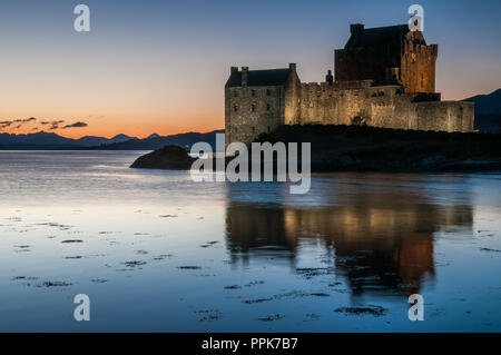 L'ancien château du 13ème siècle de séance d'Eilean Donan sur une petite île dans le Loch Alsh au coucher du soleil Banque D'Images