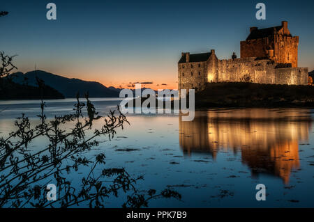 L'ancien château du 13ème siècle de séance d'Eilean Donan sur une petite île dans le Loch Alsh au coucher du soleil Banque D'Images