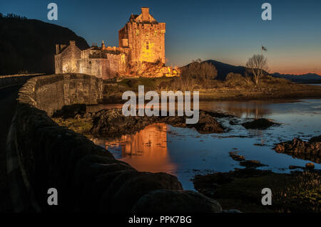 L'ancien château du 13ème siècle de séance d'Eilean Donan sur une petite île dans le Loch Alsh au coucher du soleil Banque D'Images