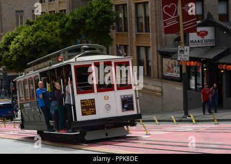 Les touristes à cheval un cable car à San Francisco, California USA Banque D'Images