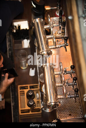 Vue sur le bar avec robinets et barmans' mains. Close up Banque D'Images