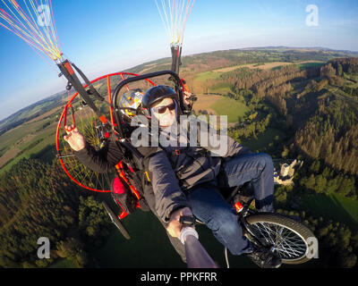 Powered parachute tandem, l'homme en tenant l'appareil photo d'action avec des selfies Banque D'Images