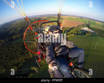 Powered parachute tandem, l'homme en tenant l'appareil photo d'action avec des selfies Banque D'Images