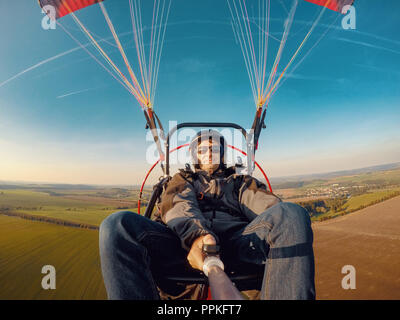 Powered parachute tandem, l'homme en tenant l'appareil photo d'action avec des selfies Banque D'Images