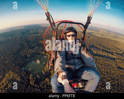 Powered parachute tandem, l'homme en tenant l'appareil photo d'action avec des selfies Banque D'Images