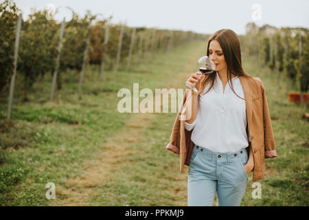 Dégustation de vin rouge vin femme à partir d'un verre dans un vignoble Banque D'Images