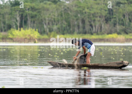 La réserve de Pacaya Samiria, Pérou, Amérique du Sud. Jeune garçon vérifier ses filets de pêche dans la région de l'Ucayali River dans le bassin amazonien. (Pour un usage éditorial uniquement) Banque D'Images