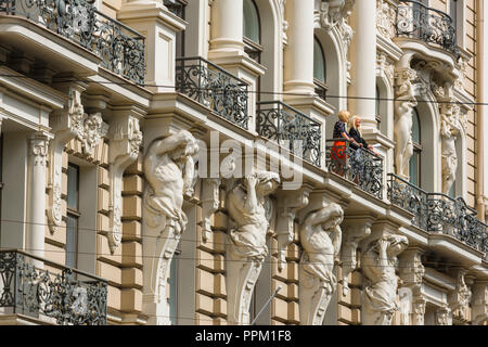 L'architecture art nouveau de Riga, vue de deux femmes se tenant debout sur le balcon d'un immeuble à la Elizabetes Iela dans le le quartier Art Nouveau de Riga. Banque D'Images