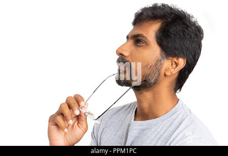 L'homme indien avec lunettes ou lunettes dans la main pense non looking at camera avec zone de texte copie isolé sur fond blanc Banque D'Images