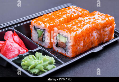 Ensemble de California rolls in a black 'enlever' conteneur sur fond noir, side view Banque D'Images