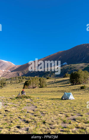 Mange Le petit-déjeuner sur un backpacker rocher près Alger lacs avec Koip Koip Pic et col en arrière-plan ; Ansel Adams Wilderness, Inyo National Forest, Sie Banque D'Images