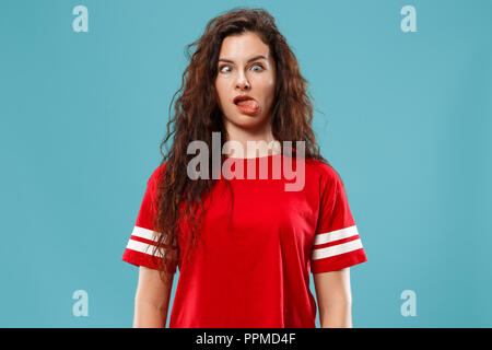 Horrible, stress, choc. Moitié femelle portrait en pied isolée au studio bleu. Jeune femme surprise émotionnelle qui serre la tête dans les mains. Les émotions humaines, l'expression faciale concept. Couleurs tendance. Vue de profil Banque D'Images