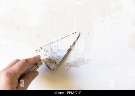 Close-up of a woman with old metal truelle, de mettre sur le mur de remplissage en plâtre Banque D'Images