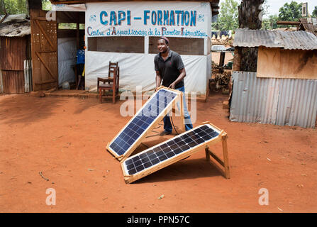 27 avril 2018, la République centrafricaine, Bangassou : Djamaladine Mahamat Salet, a 38 ans, le spécialiste de la reconstruction d'une paire de modules solaires à l'extérieur du laboratoire d'informatique il est ouverte à un camp pour personnes déplacées sur le terrain de la mission catholique, Bangassou Bangassou, en République centrafricaine, le 28 avril 2018. Salet, qui est aussi déplacé, enseigne aux quatre séances de deux heures chaque jour, du lundi au vendredi, avec 10 élèves par classe. Le prix du cours est de 10 000 CFA (environ USD$19) pour un cours de trois mois. Photo : Baxter sera/seront Baxter/dpa Banque D'Images