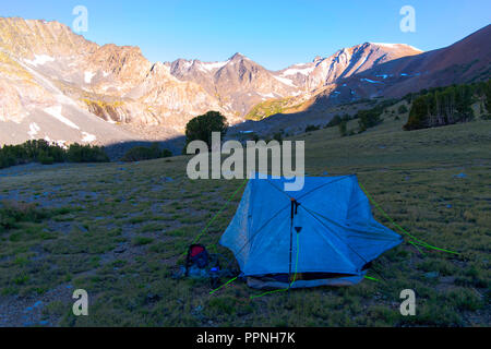 Le lever du soleil sur une tente dans la vallée près de Alger Lacs, en vue d'Koip Peak dans l'arrière-plan ; Ansel Adams Wilderness, Inyo National Forest, Sierra N Banque D'Images