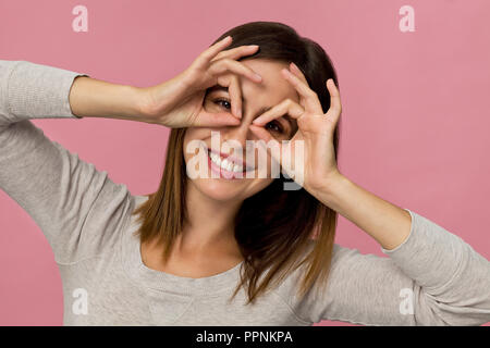 Des professionnelles du sourire close up avec aspect attrayant posant contre fond rose Banque D'Images