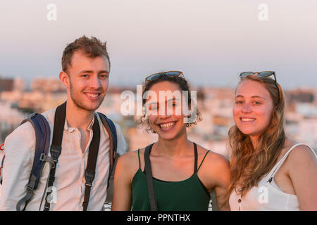 Deux jeunes femmes et jeune homme à la recherche dans l'appareil photo, les amis, la Plaza de la Encarnacion, Séville, Andalousie, Espagne Banque D'Images