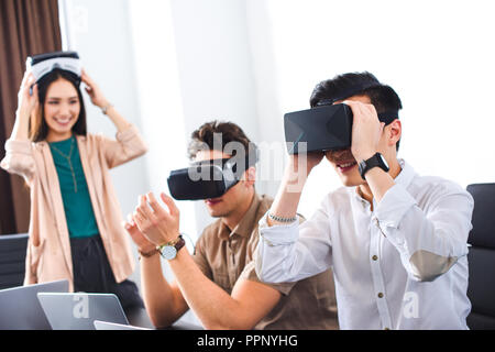 Deux smiling businessmen en utilisant les casques de réalité virtuelle au bureau moderne Banque D'Images