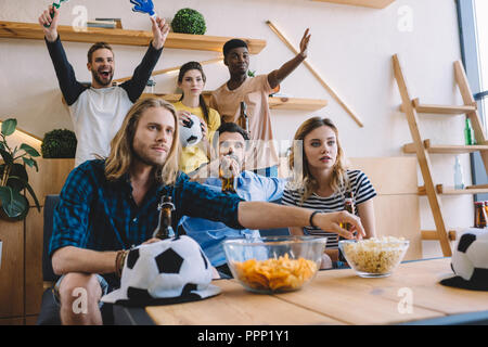 Groupe de fans de football multiculturelles regarder match de foot à la maison Banque D'Images