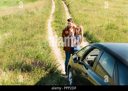 Portrait de jeune couple élégant près de location in rural field Banque D'Images