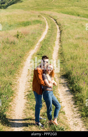 High angle view of happy couple élégant dans lunettes debout sur meadow rural Banque D'Images