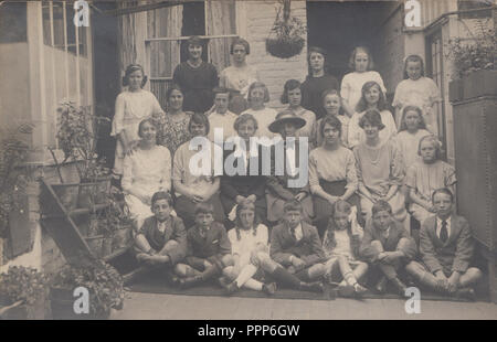 Vintage Carte postale photographique montrant ce qui semble être un groupe d'enseignants et d'enfants de l'école Banque D'Images