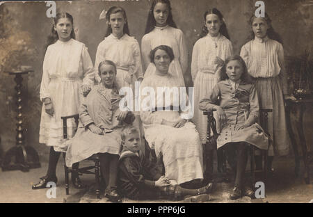 Vintage 1914 Photo d'une Dame posant avec sept filles et un garçon vêtu d'un costume de marins Banque D'Images