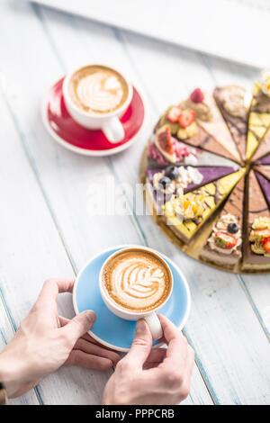 Une tasse de café d'art brut et cappiciino mini gâteaux. Banque D'Images