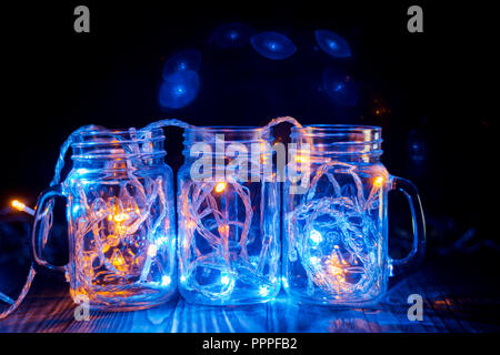 Lumières colorées dans un verre transparent pots lumières de Noël dans la salle. Banque D'Images