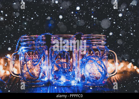 Lumières colorées dans des bocaux en verre transparent snow lumières de Noël dans la salle. Banque D'Images